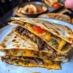 Make this Cheesesteak Quesadilla with tender steak, sautéed onions, bell peppers, and melted cheese in a crispy tortilla. It's perfect for lunch, dinner, or game day
