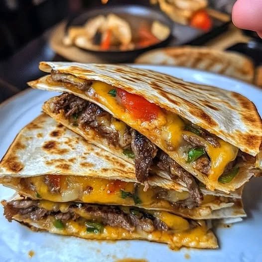 Make this Cheesesteak Quesadilla with tender steak, sautéed onions, bell peppers, and melted cheese in a crispy tortilla. It's perfect for lunch, dinner, or game day